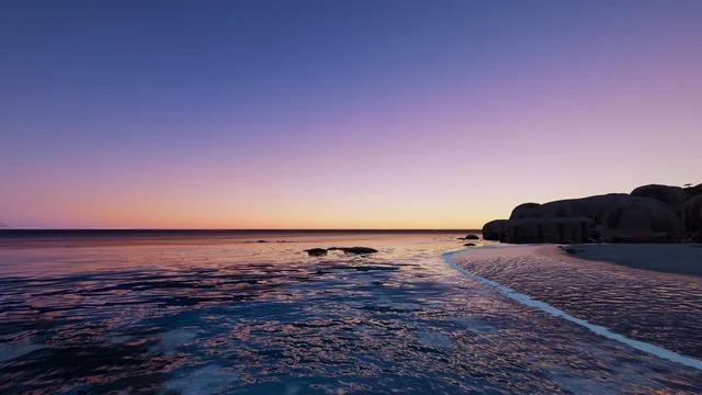 The calm sea at nightfall, with rocks to one side