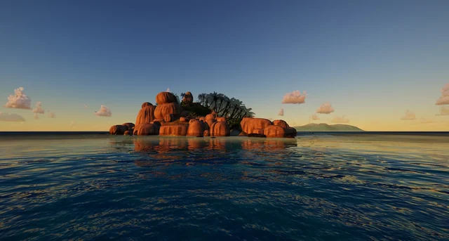 A pile of reddish rocks lit up by the sun, seen from the water